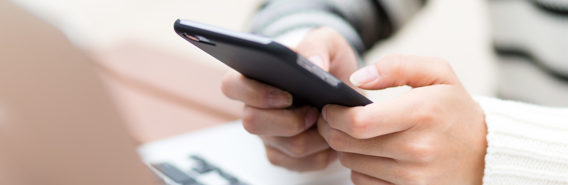 Pessoa segurando smartphone e digitando mensagem, ilustrando o uso de SMS transacional para comunicação empresarial e envio de notificações automatizadas.